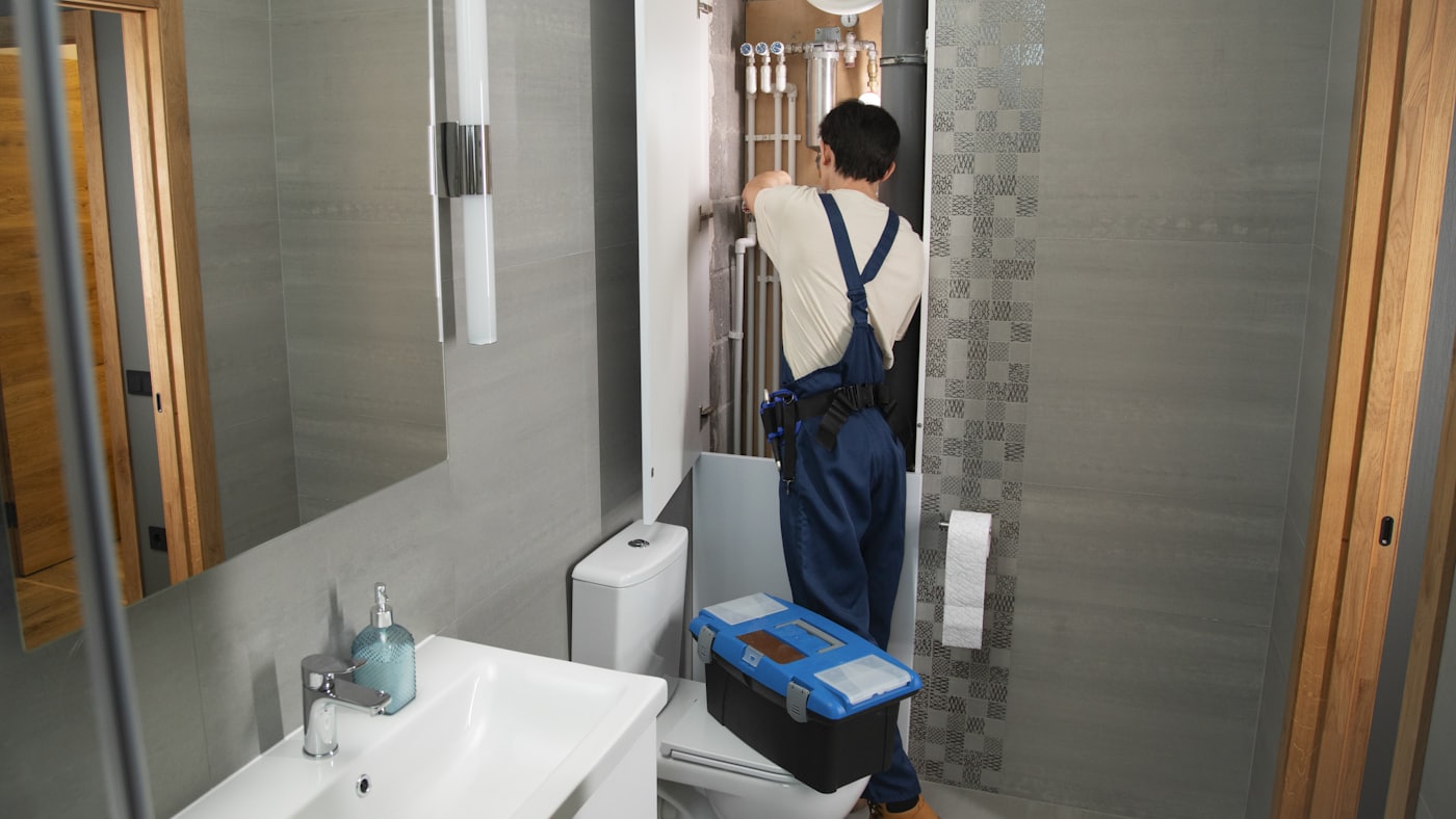 Plombier au travail dans une salle de bain résidentielle